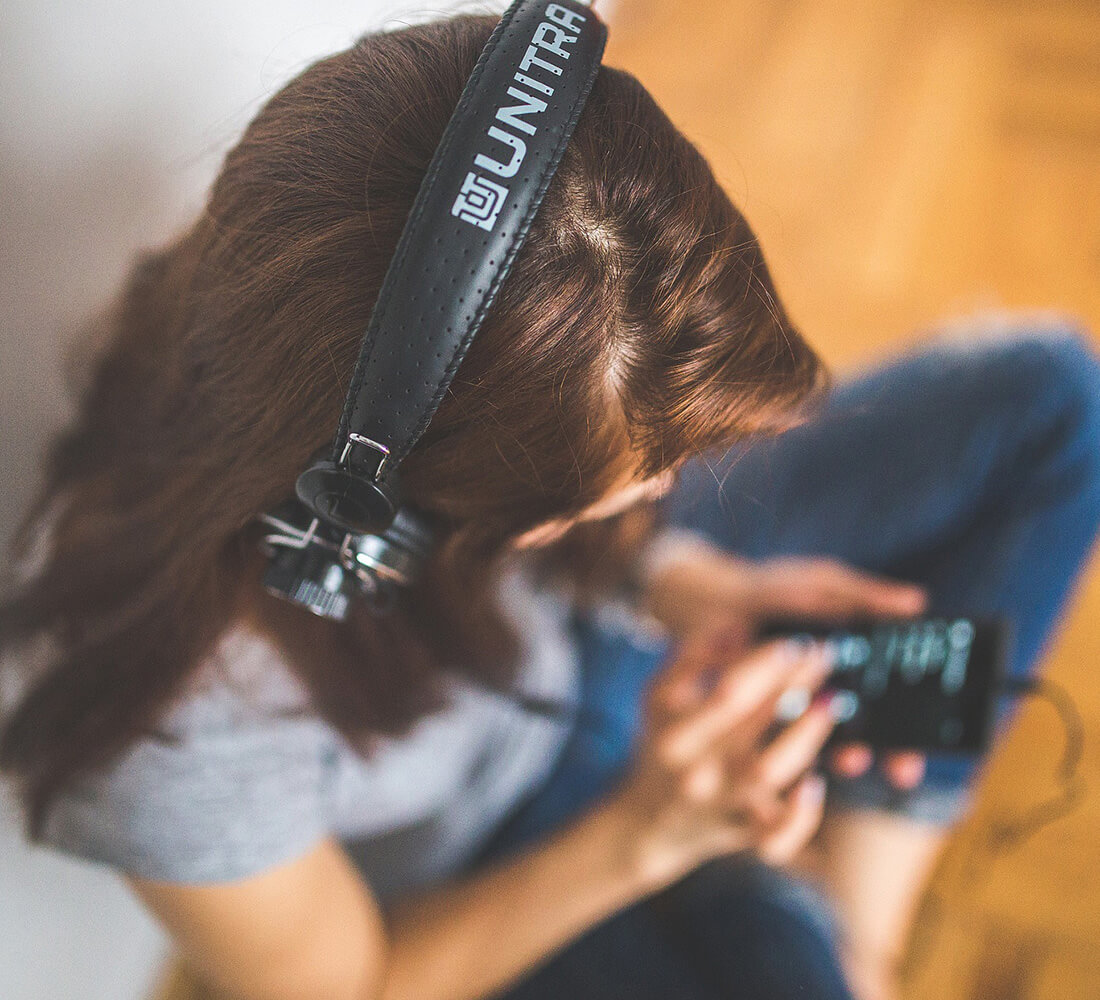 Frau hört mit Kopfhörern Musik auf dem Handy